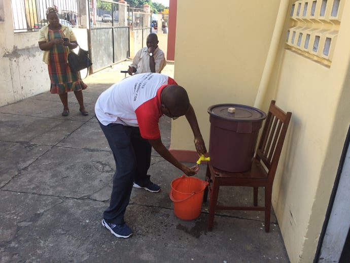 Reverendo Vicente Mauaie lavando as suas mãos antes de entrar no edifício da IMUM em Maputo. Foto de João Filimone Sambo