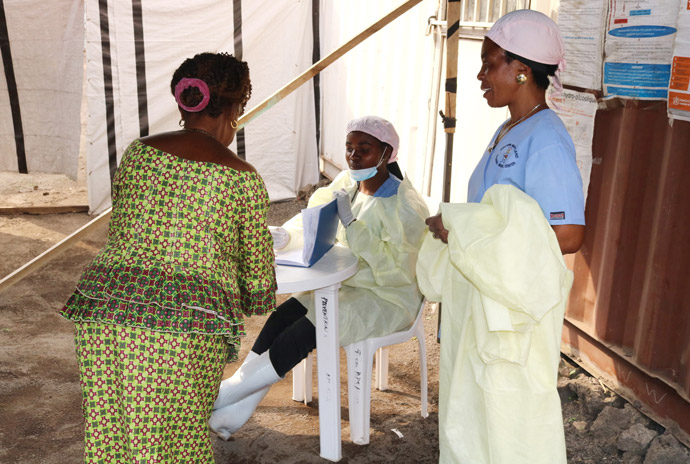 Nurse Anny Butunga (seated) takes information from a patient in an Ebola isolation room at Irambo United Methodist Hospital in Bukavu, Congo, as another nurse looks on. All of the Ebola isolation rooms at United Methodist hospitals in the region are being transformed into COVID-19 isolation centers. Photo by Philippe Kituka Lolonga, UM News. 