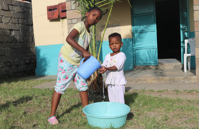 Nine-year-old Shantel Resse washes the hands of her younger sister, Reina Muthoni, at Kayole St. John’s United Methodist Church in Nairobi, Kenya. Churches in Kenya are urging members to wash their hands using soap or hand sanitizer to stop the spread of the coronavirus. Photo by Gad Maiga, UM News.