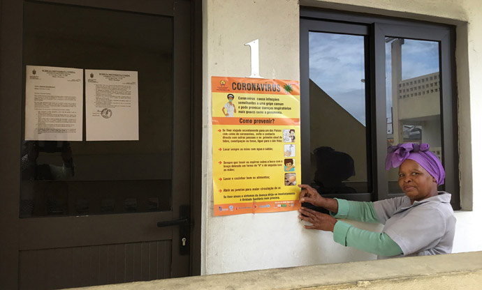 United Methodist Rita Samuel points to a poster that shares tips for stopping the spread of the coronavirus in Maputo, Mozambique. Photo by João Filimone Sambo, UM News.