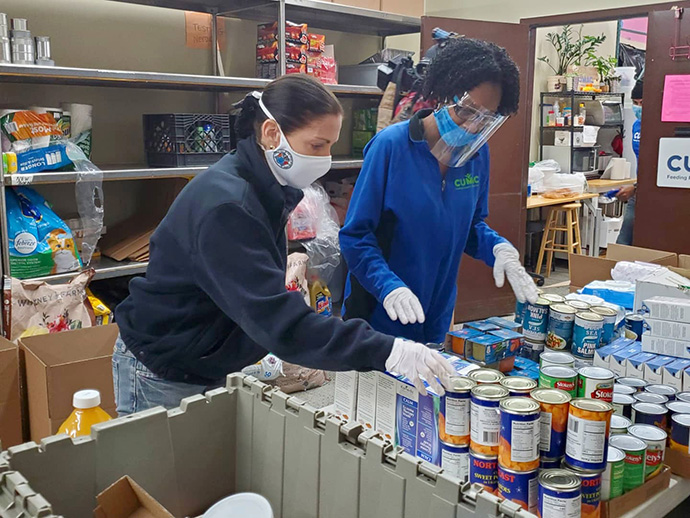 Tammy Murphy (left), the First Lady of New Jersey, helps Kay Ann Foster pack food boxes for mothers and children during a May 14 stop at CUMAC, a food organization in Paterson, N.J., that is one of 23 designated “Hope Centers” of the United Methodist Greater New Jersey Conference. Photo courtesy of CUMAC.