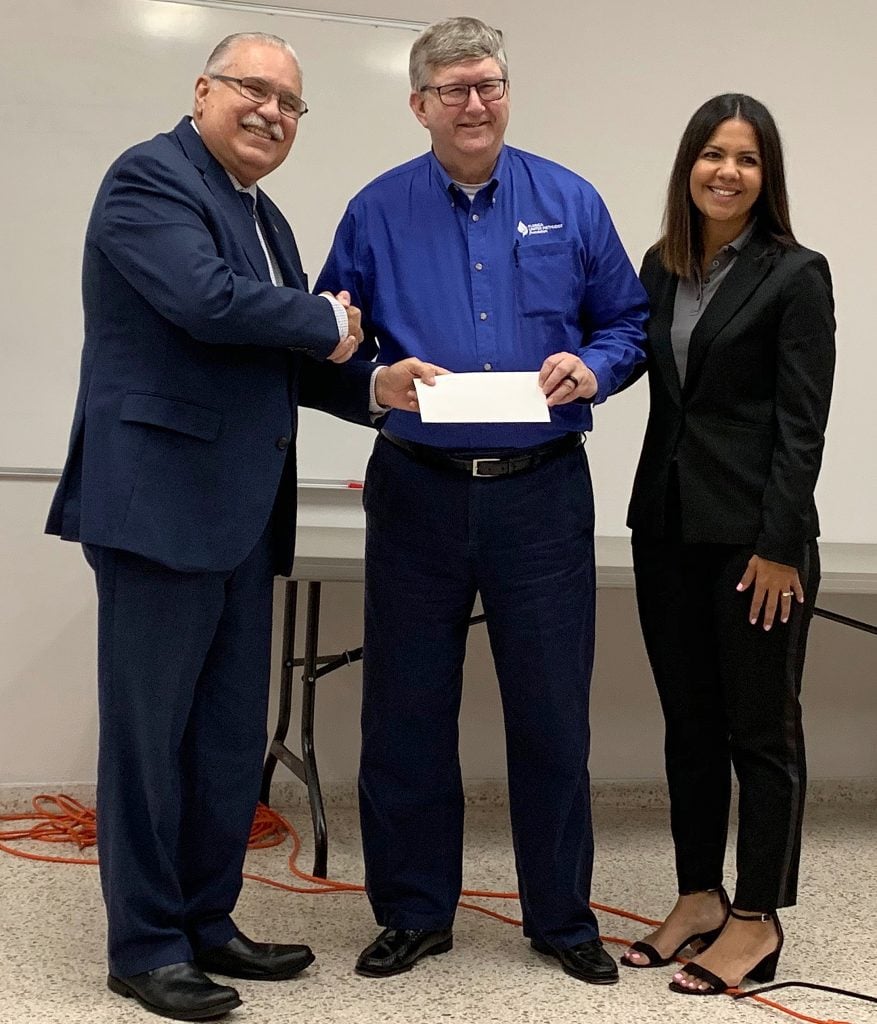 O reverendo Mark Becker (centro) apresenta um cheque de US $ 50.000 ao bispo Hector F. Ortiz, líder episcopal da Igreja Metodista de Porto Rico, e Glorymar Rivera-Báez, diretor do programa de recuperação de desastres do Rebuilding Communities with Hope (REHACE). Os fundos ajudarão a REHACE a fornecer gerenciamento de casos e terapia de cuidados emocionais aos porto-riquenhos afetados pelos terremotos. Foto por Tita Parham, FUMF.