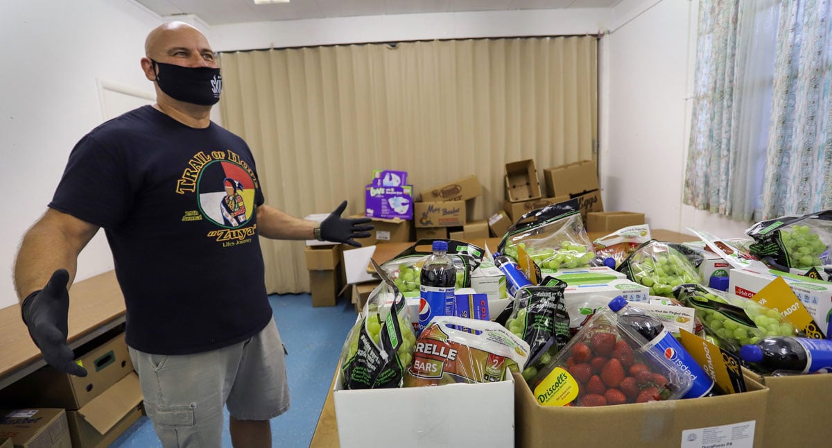 The Rev. Larry Robinson, pastor of Tulsa Indian United Methodist Church in Tulsa, Okla., shows off boxes of food ready to be distributed to community members in need. The church was able to purchase 26 pounds of bread and 400 pounds of bulk produce for the food pantry through a grant provided by the Native American Community Response Fund. Photo by Ginny Underwood, UM News.