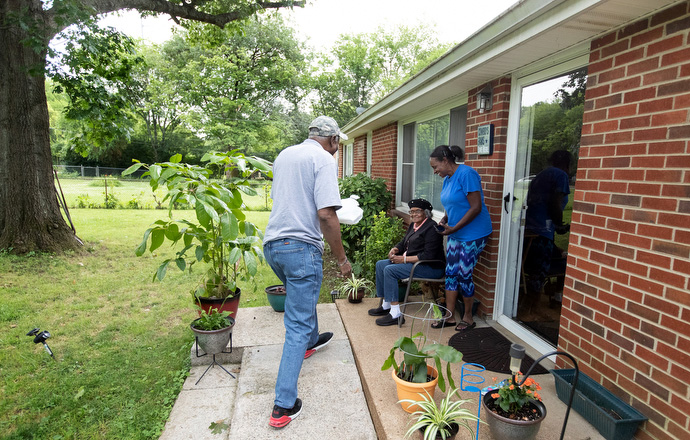 Volunteer James Brooks (left) delivers a meal to Dora Mason (seated) as part of the Best Years program for seniors at Gordon Memorial United Methodist Church in Nashville, Tenn. The program received a Sheltering in Love grant from the United Methodist Committee on Relief. At right is Mason’s daughter, Trever Mason-Hobson. Photo by Mike DuBose, UM News.