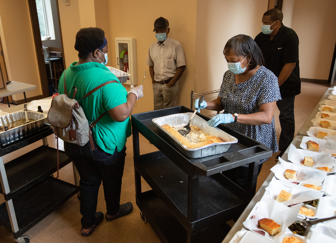 Volunteers Jerlean Bass (left) and Anita Armstrong prepare box lunches for distribution through the Hands of Hope food security program at Gordon Memorial United Methodist Church in Nashville, Tenn. Behind them are volunteers Matthew Job (left) and Richard Wilson. Photo by Mike DuBose, UM News.