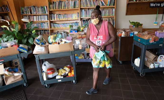 Volunteer Dee Farr carries donated food for a client at the Branch of Nashville emergency food assistance program at Antioch (Tenn.) United Methodist Church. The program received a Sheltering in Love grant from the United Methodist Committee on Relief to assist vulnerable communities during the COVID-19 pandemic. Farr said she once received assistance from the program and has been returning regularly to volunteer. Photo by Mike DuBose, UM News.