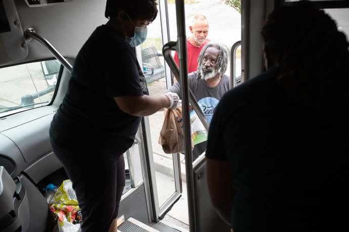 The Rev. Michelle Wilson (left) offers sack lunches from the door of the church van as part of the Hands of Hope food security program at Gordon Memorial United Methodist Church in Nashville, Tenn. Photo by Mike DuBose, UM News.