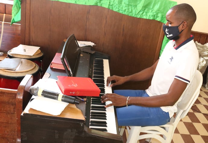 Mestrinho Jairo Fontoura da Silva tocando piano durante o culto de reabertura. Malange, foto de João Gonçalves Nhanga.