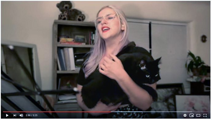 Shea Perry, choir member of St. John’s United Methodist Church in Albuquerque, New Mexico, has feline company as she performs a solo for a virtual choral performance of “Creation of Peace” by Mark Miller. YouTube screengrab by UM News.