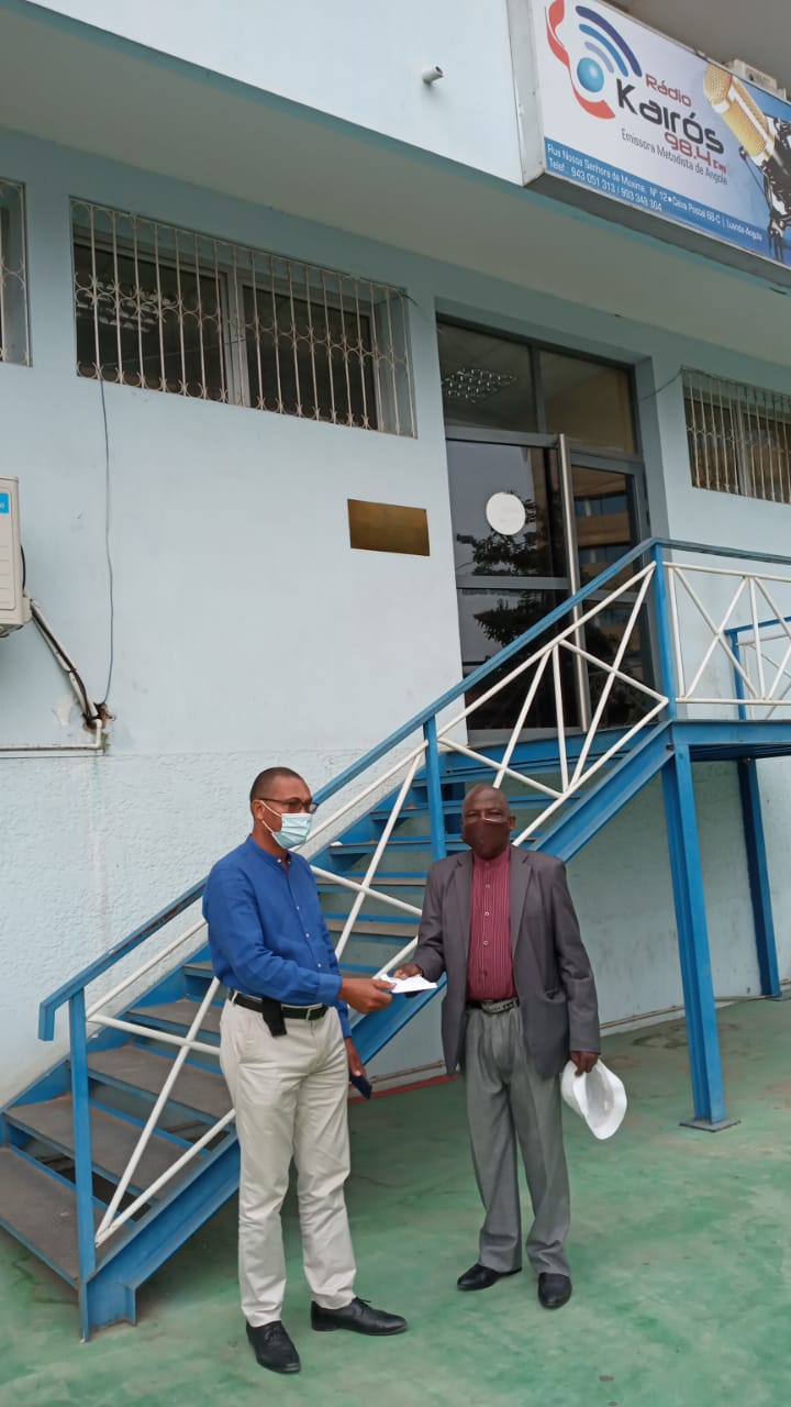 Doador fazendo entrega da sua doação ao Presidente do Conselho de Finanças do Oeste Nabeiro Mateus, em frente à Rádio Kairós-Luanda. Foto Augusto Bento.