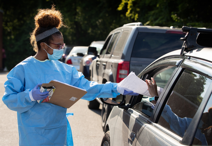 Tamera Thomas hands out paperwork to people waiting for a COVID-19 test at a drive-thru site offered by Meharry Medical College at St. Luke Christian Methodist Episcopal Church in Nashville. Thomas is a dental student at the medical school. Photo by Mike DuBose, UM News.