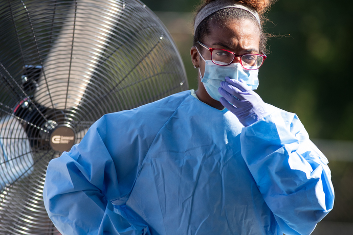 Tamera Thomas takes a moment to cool off between helping patients at a drive-thru COVID-19 testing site offered by Meharry Medical College. Photo by Mike DuBose, UM News.