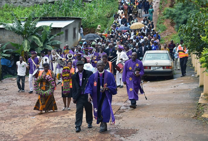 Bishop John K. Yambasu and clergy from the Sierra Leone Council of Churches lead a procession of worshippers to an area at the bottom of Mount Sugar Loaf where hundreds of bodies that were not recovered are still buried under the rubble of a devastating landslide. A service of remembrance and thanksgiving for the victims and survivors was held at the bottom of Mount Sugar Loaf, Aug. 27, 2017. File photo by Phileas Jusu, UM News.