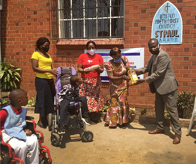 Students at the Chengaose Day Care Center Trust for physically challenged children receive food aid at St. Paul United Methodist Church in Mbare, Zimbabwe. A grant from the United Methodist Committee on Relief helped purchase more than 900 hampers filled with basic food items, including cooking oil, mealie meal (cornmeal), sugar, rice, beans and soya chunks. Photo by Chenayi Kumuterera, UM News. 