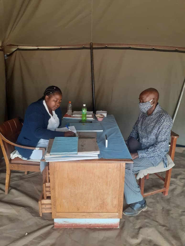 Portia Gogode attends to patient Steven Nyakudarika, 73, inside a tent set up outside Old Mutare Mission Hospital in Mutare, Zimbabwe. Tents are being used to protect patients and staff during the pandemic. Photo by Kudzai Chingwe, UM News.