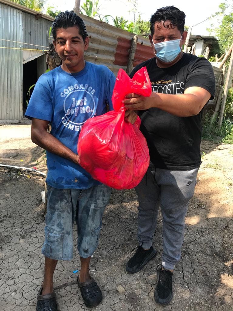 El Pastor Félix Medina (derecha), junto con voluntarios/as de la IMU Casa de Paz reparten alimentos, donados por miembros de la comunidad, entre familias que han sido afectadas en las áreas vecina a la iglesia. Foto cortesía de la IMU Casa de Paz.