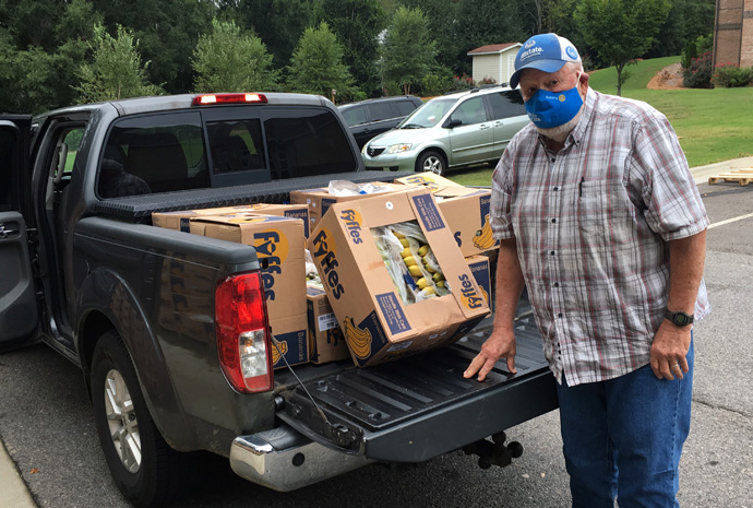 B.J. Copeland loads boxes of bananas into the back of his truck. Copeland is one of a group of volunteers who help haul produce to centers that are able to get the food to churches and food banks. Photo courtesy of B.J. Copeland.