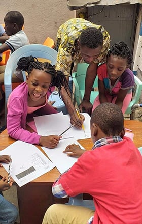 Innocent Phrytoil Afful assists children with their schoolwork in Kinshasa, Congo. Photo courtesy of Innocent Phrytoil Afful.