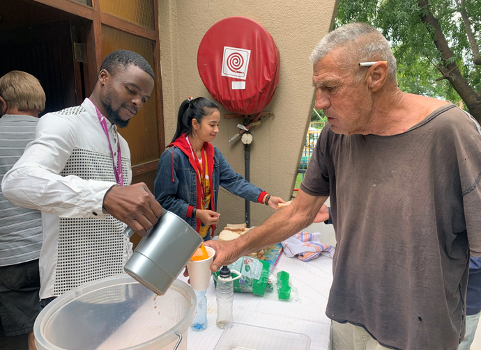 Missionary Chanmony Ek (center) helps serve food and drink to needy people in South Africa. Photo courtesy of Chanmony Ek.