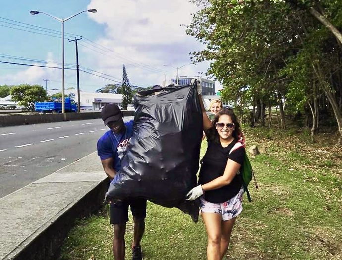 Moinina Minah (left), a missionary in St. Lucia, helps haul trash from a beach there with other climate defenders. Photo courtesy of Moinina Minah.