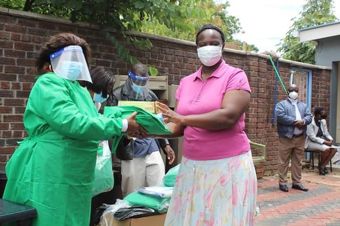 The Rev. Anesu Katsande (left) displays the personal protective equipment that was distributed to all pastors and evangelists in the Harare West District of The United Methodist Church in Zimbabwe. Katsande is superintendent of the Harare West District. Photo courtesy of Eunice Kadiki, HWD Communications.