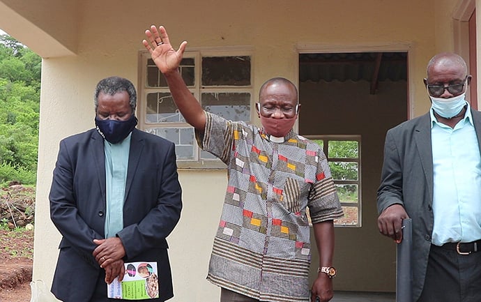 The Rev. Alan Gurupira (center) prays during the dedication ceremony for new homes built for survivors of Cyclone Idai in Bikita, Zimbabwe. Photo by Priscilla Muzerengwa, UM News.