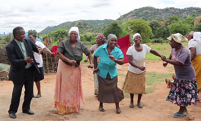 The Rev. Jairos Mafondokoto (left) joins women in Bikita, Zimbabwe, in celebrating the dedication of new homes built with funds from the Baltimore-Washington Conference of The United Methodist Church for survivors of Cyclone Idai. Mafondokoto is superintendent of the Masvingo District of The United Methodist Church in Zimbabwe. Photo by Priscilla Muzerengwa, UM News.