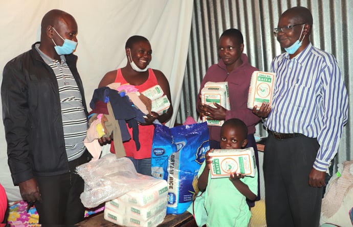 Pastors share a joyful moment with a family after providing them with food items from the Nairobi District’s Homeless Compassion Ministry. The United Methodist program is providing relief for the homeless in Kenya, who are especially vulnerable during the global pandemic. Photo by Gad Maiga, UM News.