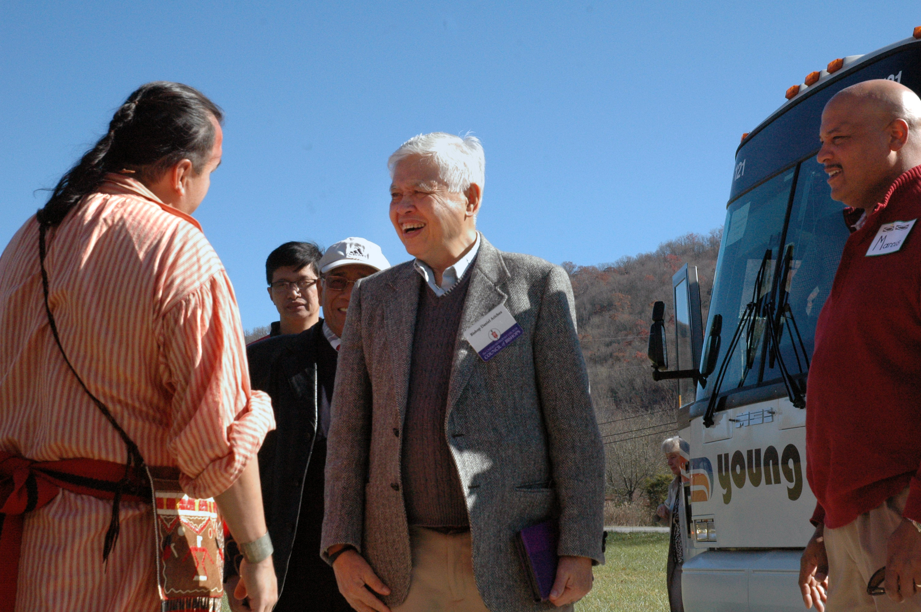 Retired Bishop Daniel C. Arichea Jr. (center) is greeted by Bo Taylor (left) and Marcus Robinson (right), both members of Cherokee United Methodist Church, during a trip to Cherokee, N.C. Members of the United Methodist Council of Bishops participated in an “emersion experience” during the 175th year anniversary of the Trail of Tears. 2013 file photo by Annette Spence.