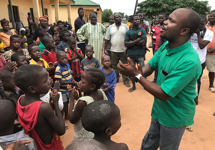 The Rev. Ande Emmanuel leads children in singing at a camp for internally displaced persons in Jalingo, Nigeria, in 2019. Emmanuel was the longtime administrative assistant to Bishop John Wesley Yohanna, but Yohanna replaced him earlier this year. Emmanuel has accused the bishop of punishing him and others committed to staying in The United Methodist Church in the case of a denominational split. The bishop has denied punitive actions but says Emmanuel and others have disrupted the Nigeria Episcopal Area. File photo by Tim Tanton, UM News.