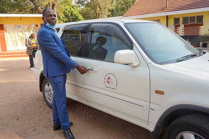 The Rev. Godknows Risinamhodzi, Chitungwiza Marondera District superintendent, unlocks a new vehicle that will be given to Learnmore Rungwandi, pastor in charge of the Hwedza United Methodist Circuit near Wedza, Zimbabwe. Rungwandi had been walking long distances to minister to her four local churches spread over a 37-mile radius. Photo by Kudzai Chingwe, UM News. 