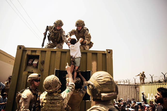 UK and Turkish coalition forces and U.S. Marines assist a child during an evacuation at Hamid Karzai International Airport in Kabul, Afghanistan, on Aug. 20. While the last U.S. forces have left the country, United Methodists are still working with ecumenical partners there to improve conditions for people in Afghanistan. Photo by U.S. Marine Corps Staff Sgt. Victor Mancilla, courtesy of the U.S. Department of Defense.