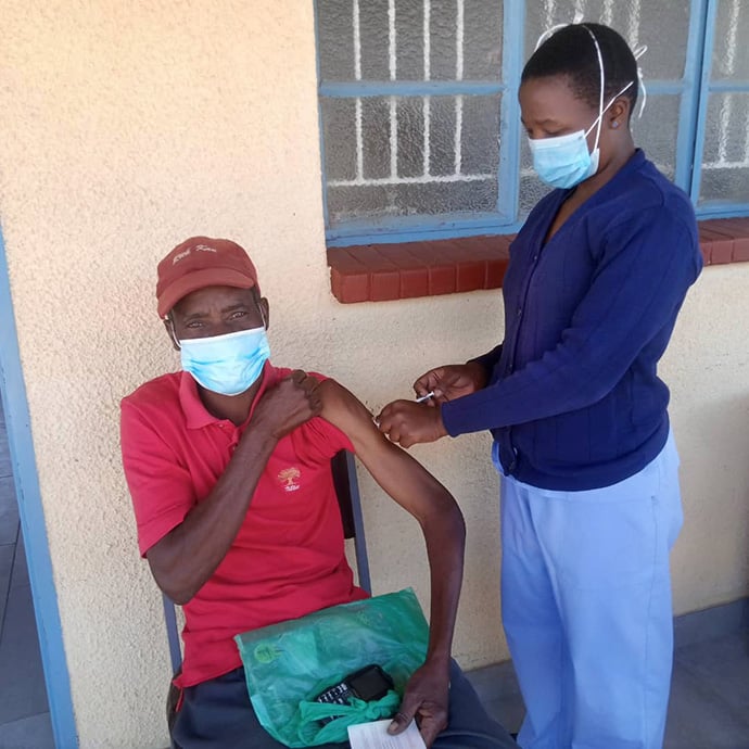 Pharaoh Mukototsi receives a COVID-19 vaccination from nurse Belinda Mashoko at The United Methodist Church’s Dindi Clinic in Zimbabwe. Photo by Kudzai Chingwe, UM News.