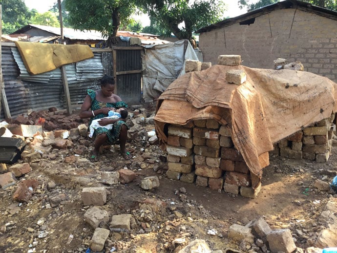 Pauline Fedoyne, Présidente des Femmes de l'Église Méthodiste Unie en Centrafrique (FEMUCA) avec son bébé dans les ruines de sa maison détruites par les eaux. Mère de trois enfants, Pauline est l’une des méthodistes unies touchés par cette catastrophe. Des inondations après le débordement des eaux du fleuve Obangui ont submergé des maisons en août à Bangui, la capitale de la République Centrafricaine. Photo de Chancelvie Petula, UM News.