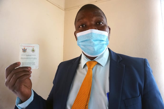 The Rev. Shepherd Fusire of Mutoko United Methodist Church in Mutoko, Zimbabwe, shows his vaccination card. In August, the government announced that only fully vaccinated members could participate during in-person worship, but that decision was changed in September. Photo by Kudzai Chingwe, UM News. 