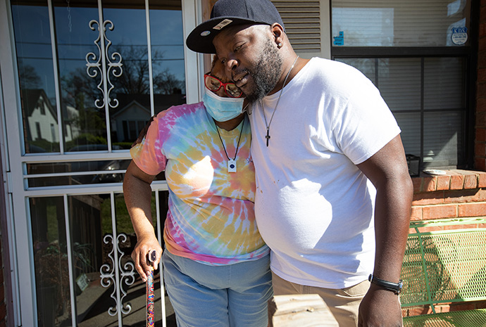 Meals on Wheels driver Roy Reed hugs Frances Hereford after bringing lunch prepared by staff and volunteers at Bethlehem Centers. Photo by Mike DuBose, UM News.