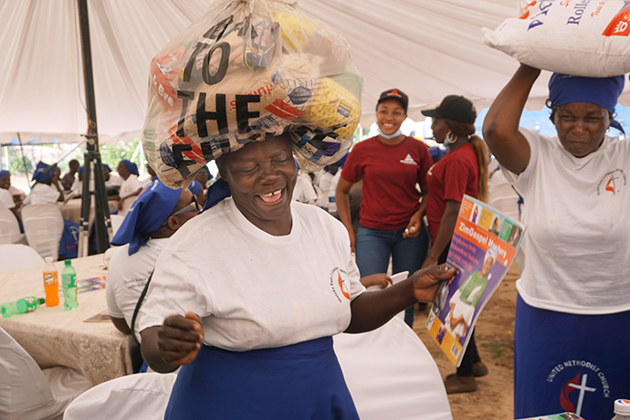 Tsitsi Katsande (left) celebrates after receiving a food parcel at Bwanya United Methodist Church at a surprise Christmas party hosted by a local family. Photo by Kudzai Chingwe, UM News.