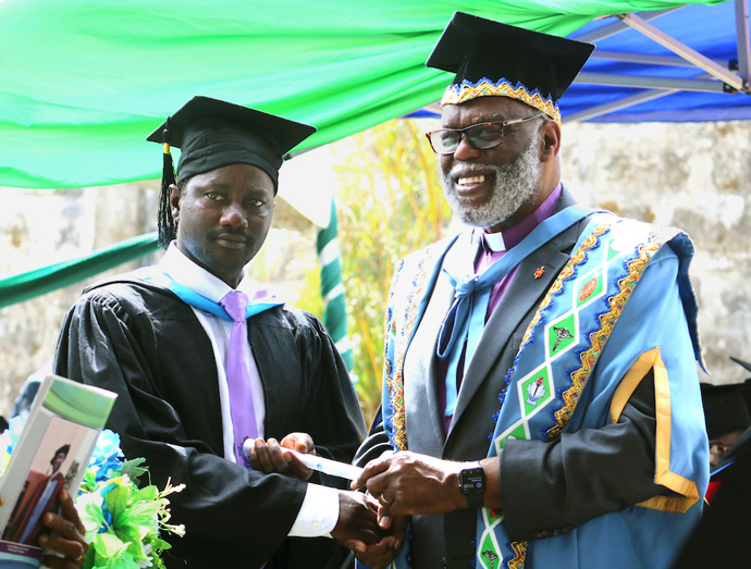 Warner H. Brown (à droite), évêque intérimaire de la Conférence de Sierra Leone, remet un certificat symbolique de licence en théologie avec spécialisation en éducation chrétienne au Révérend Stephen N. Senesie. Senesie fait partie des premiers étudiants à être diplômés de l’Université Méthodiste Unie de Sierra Leone, qui a ouvert ses portes fin 2017. Photo de Phileas Jusu, UM News.