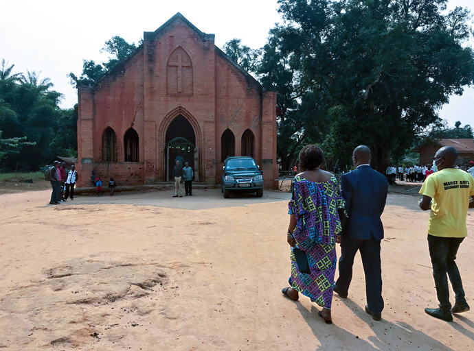 L’évêque Gabriel Yemba Unda (en costume bleu) de la Région épiscopale du Congo Est et son épouse, la Dr Marie-Claire Diandja, visitent la chapelle de Tunda, la première église construite dans la mission Méthodiste Unie de Tunda par les premiers missionnaires américains en 1922. Photo de Chadrack Londe, UM News.