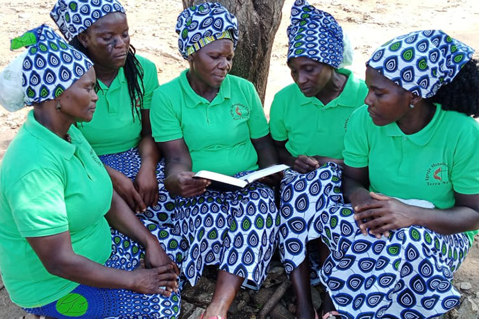 Algumas mulheres da Comunidade de Terra Nova em Bengo, Angola, sentadas debaixo duma sombra fresca, deliciam-se da palavra de Deus. Foto de Augusto Bento.