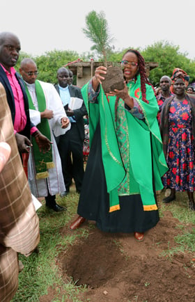 The Rev. Kimberly Scott, a board member of Reconciling Ministries Network and pastor of Cross Roads United Methodist Church in Phoenix, plants a tree at First United Methodist Church Moheto, Nyanza District, Kenya, during the dedication of the church building on July 31. Photo by Gad Maiga, UM News.