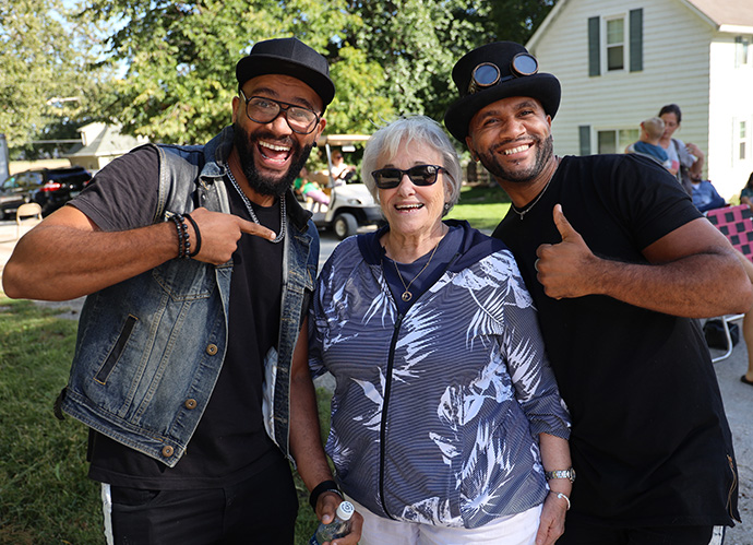 The Rev. Sandy Smith poses with the B2wins, identical twin brothers Walter and Wagner Caldas from Brazil, who perform classic songs rearranged for violin and ukulele, at the Booneville Music Festival. Smith, now retired, helped get the festival started in 2018. Photo by Courtney Levin, Iowa Conference. 