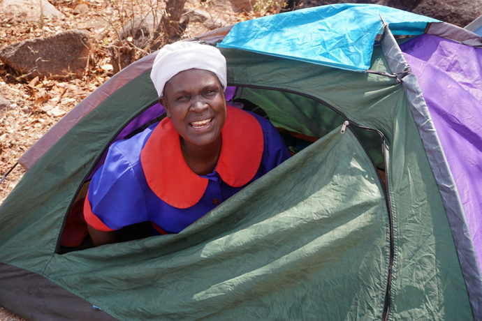 Chinyenya Maagandaline smiles from inside her tent during a United Methodist-sponsored event to bring people to Christ in the Marange District in Zimbabwe. Even though the district faced challenges like heavy rains and strong winds, members of the organizing team continued their mission. Photo by Kudzai Chingwe, UM News.