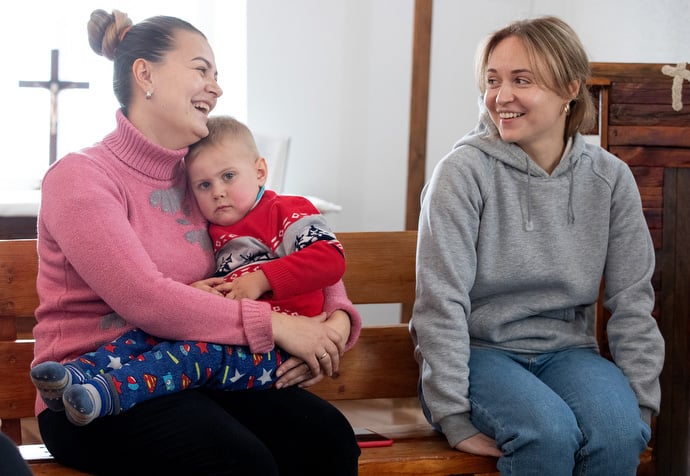 Marina Tkacheva, holding her son, Stepan, shares a laugh with Elena Lysina, who leads the women's group at Kainda United Methodist Church in Kainda, Kyrgyzstan. Photo by Mike DuBose, UM News.