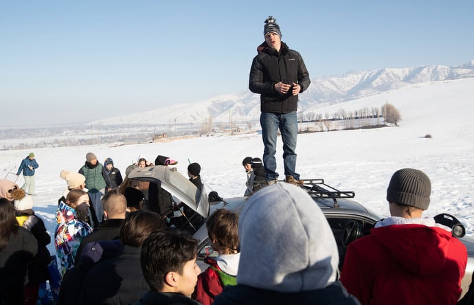 Fyodor Seriakov stands on top of a car to talk with young people who have been enjoying an afternoon of sliding in the snowy Tian Shan mountains, an activity sponsored by Livespring United Methodist Church in Kara-Balta, Kyrgyzstan. Photo by Mike DuBose, UM News.