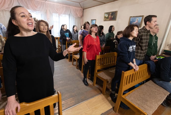 The Rev. Nellya Shakirova (front) joins the congregation in singing during worship at Bishkek United Methodist Church. Photo by Mike DuBose, UM News.