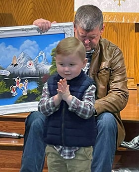 Scott Holloway, a former member of the disaffiliating First United Methodist Church of Jonesboro (Ark.), delivers the children’s message during a worship service for church members planning to remain United Methodist. The worship service was held at First Presbyterian Church of Jonesboro, where the loyal Methodists are meeting. The child is Isaac George. Photo courtesy of the Rev. Britt Skarda.