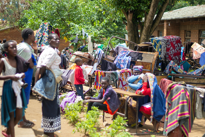 People sit among blankets and belongings at a refugee camp set up at Manja Primary School in Blantyre after Tropical Cyclone Freddy swept through southern Malawi.  According to the Department of Disaster Management Affairs, more than 500,000 people have been affected, including 183,000 displaced people across 13 districts. Photo by Francis Nkhoma, UM News.