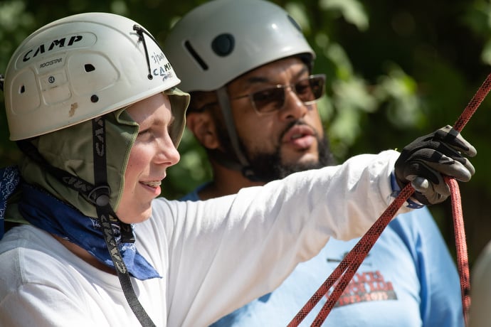 Colin Harward (left) learns to belay a rock climber under the watchful eye of Will Brown during a class at the Boxwell Scout Reservation. Brown, an assistant scoutmaster with Troop 2223 in La Vergne, Tenn., volunteered to help teach climbing skills during summer camp. Photo by Mike DuBose, UM News.