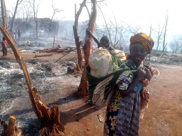 Asende Lumumba Milando, 40, stands in the Malicha camp for displaced people in the Fizi territory of South Kivu, Congo, where 1,000 makeshift shelters burned in a fire on Aug. 19. The mother of seven lost everything she owned in the fire. Photo by Philippe Epanga, courtesy of the Bureau de Gestion des Catastrophes de la Région Épiscopale du Congo Est.